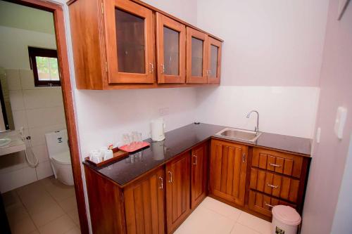 a kitchen with wooden cabinets and a sink at Airport Villa in Katunayake