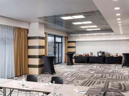 a conference room with tables and chairs and a lobby at Mercure Bucharest Unirii in Bucharest