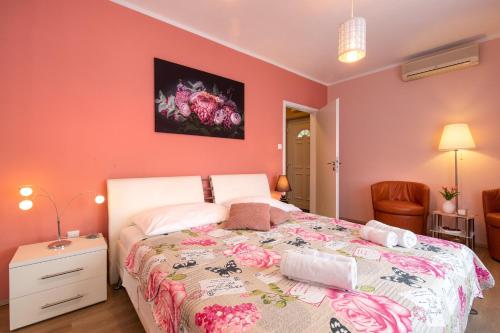 a bedroom with a large bed with pink walls at Apartman Ruza in Krk