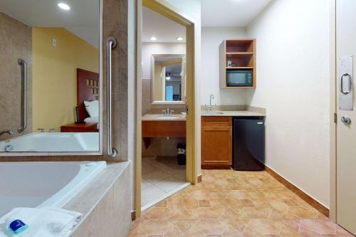 a bathroom with a tub and a sink at Rodeway Inn & Suites Fort Lauderdale Airport & Cruise Port in Fort Lauderdale