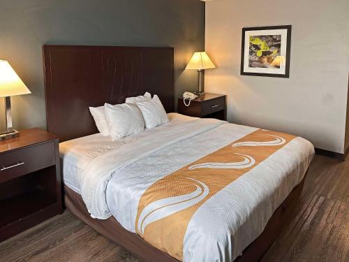 ein großes Bett in einem Hotelzimmer mit zwei Lampen in der Unterkunft Quality Inn in Montpelier