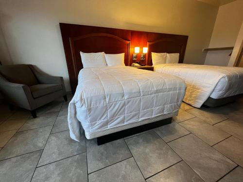 a hotel room with two beds and a chair at Casa Rosa Inn in Port Isabel