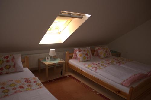 a attic room with two beds and a skylight at Hostinec vo Višňovom in Stará Turá