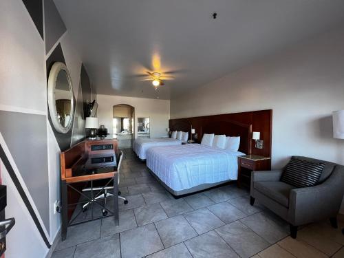 um quarto com uma cama, uma secretária e uma cadeira em Casa Rosa Inn em Port Isabel