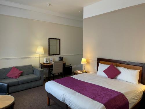 Pokój hotelowy z dużym łóżkiem i krzesłem w obiekcie The Grand Scarborough w Scarborough
