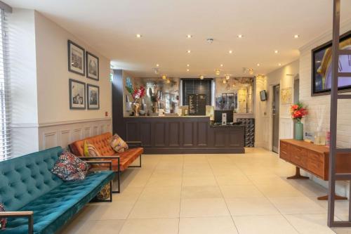 a lobby with a blue couch and a bar at Hotel Balmoral in Newcastle upon Tyne