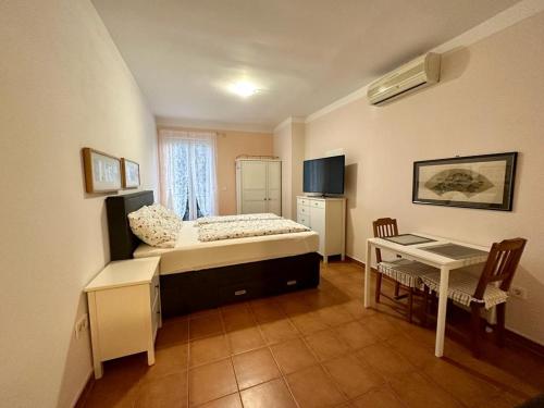 a bedroom with a bed and a table and a desk at Ivana apartman 3 in Crikvenica
