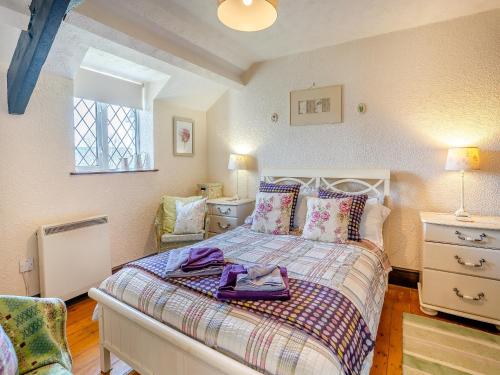 a bedroom with a bed with a purple robe on it at Ty Gwyn - Jyy in Gowerton