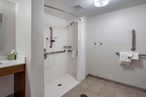 a white bathroom with a shower and a sink at MainStay Suites Lexington I-75 in Lexington