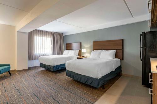 a hotel room with two beds and a television at MainStay Suites Lexington I-75 in Lexington
