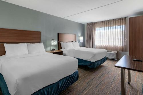 a hotel room with two beds and a desk at MainStay Suites Lexington I-75 in Lexington