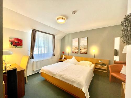 ザールブルクにあるHotel Saarburger Hofのベッドルーム1室(ベッド1台、椅子、窓付)