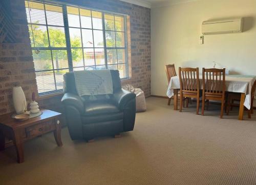 a living room with a chair and a table at Stay on Lachlan in Cowra