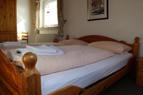 a bedroom with a bed with white sheets and a window at Hotel-Restaurant Olympia in Selm