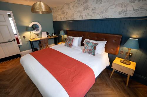 a bedroom with a large bed with a red blanket at Victoria Hotel by Chef & Brewer Collection in Menai Bridge