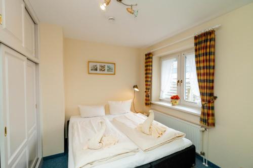 a bedroom with a bed with towels on it at Godewind ebenerdig in Westerland