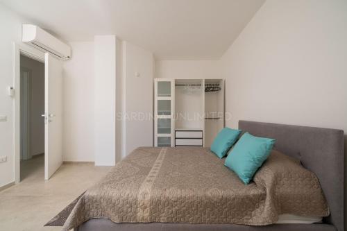 um quarto com uma cama com duas almofadas azuis em Villetta Milla em Cannigione