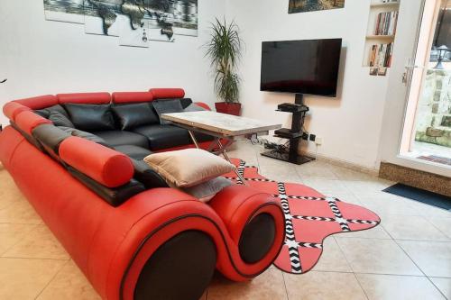 un sofá rojo sentado en una sala de estar en Villa confortable avec Jacuzzi à Chevannes, en Chevannes