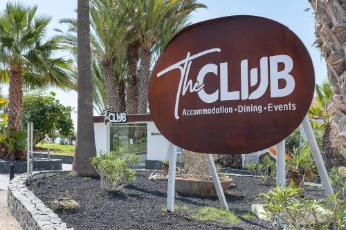 a sign in front of a building with palm trees at THE CLUB - Accommodation - Dining - Events in San Miguel de Abona