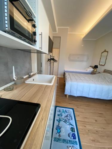 una cocina con fregadero y una cama en una habitación en Camera via Roma en Follonica