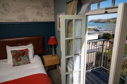 Schlafzimmer mit einem Bett und einer Tür zu einem Balkon in der Unterkunft Victoria Hotel by Chef & Brewer Collection in Menai Bridge