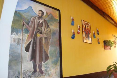 a large painting of a pope on a wall at Hotel Las Camelias Inn by AHS in Antigua Guatemala