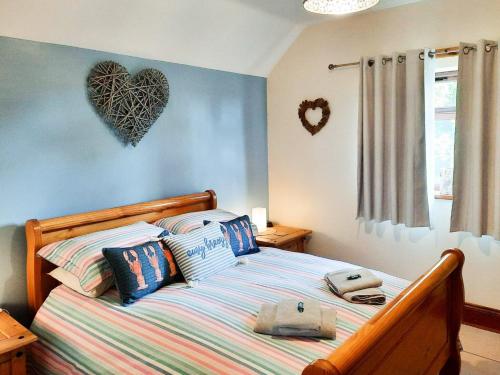 AnderbyにあるHarvest Cottageのベッドルーム1室(壁にハートを配置したベッド1台付)
