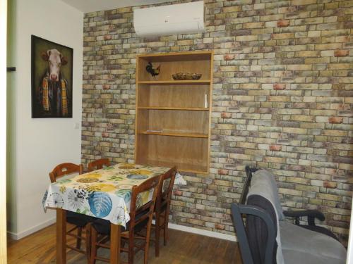 une salle à manger avec un mur en briques dans l'établissement chez Stella 1 chambre et 1 coin lits, à Criel-sur-Mer