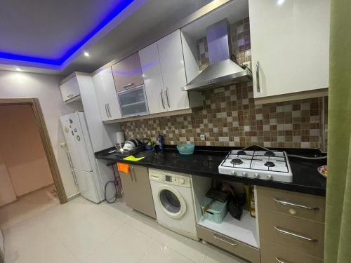 a kitchen with a stove and a washing machine at Super Cozy Large Double Bedroom ONLY with Shared Facilities-Free Wifi, Netflix - Many local Shops in Esenyurt