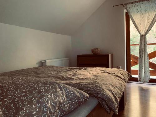 a bedroom with a bed and a large window at Chata Mošnica in Lazisko