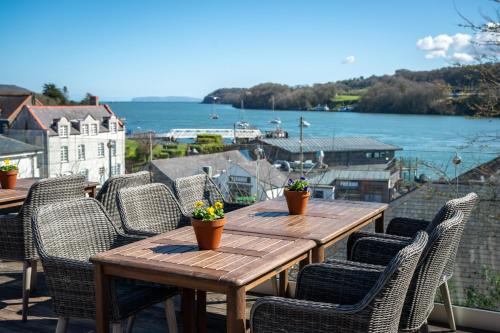 a wooden table and chairs on a balcony with a view of the water at Victoria Hotel by Chef & Brewer Collection in Menai Bridge