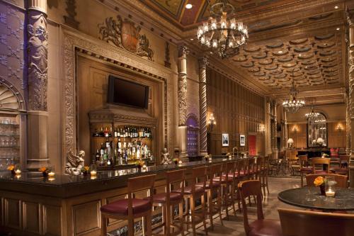 a bar in a restaurant with a lot of stools at The Biltmore Los Angeles in Los Angeles