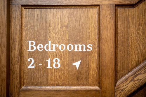 a wooden door with the words bathrooms on it at Victoria Hotel by Chef & Brewer Collection in Menai Bridge
