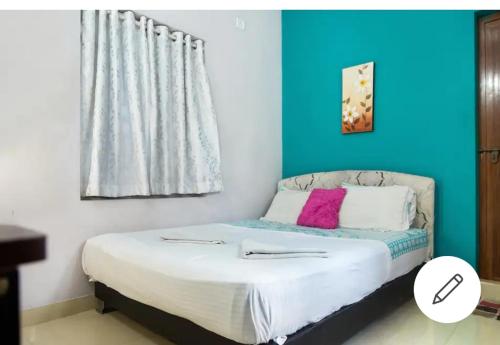 1 dormitorio con 1 cama con pared azul en The niyanest en Kochi