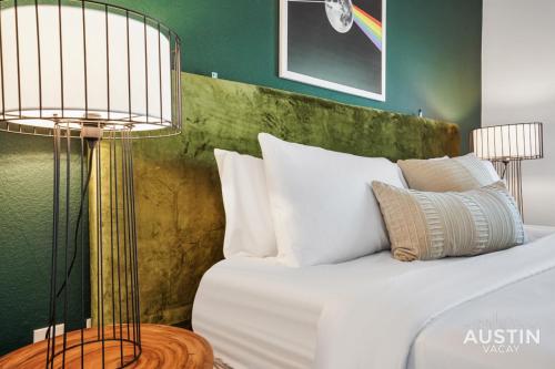 a bedroom with a bed with white pillows and two lamps at Stylish 4BR with Smart TV and Free Garage Parking in Austin
