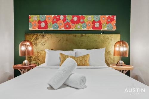 a bedroom with a large white bed with two lamps at Stylish 4BR with Smart TV and Free Garage Parking in Austin