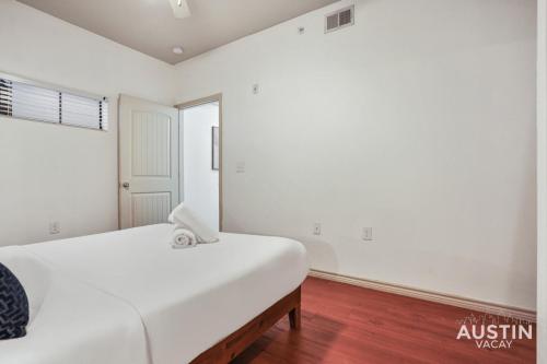 a white bedroom with a bed and a window at Stylish 4BR with Smart TV and Free Garage Parking in Austin