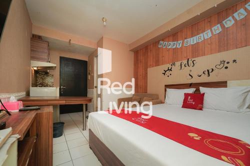 een slaapkamer met een bed met een rood uitnodigend bord erop bij RedLiving Apartemen Paragon Village Karawaci - Ujang Uchil Rooms in Tangerang