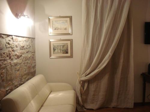 a living room with a white couch and a curtain at Case Brizi Assisi in Assisi