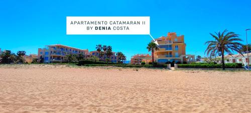 a view of a beach with buildings and palm trees at Apartamento Catamarán II by DENIA COSTA in Denia