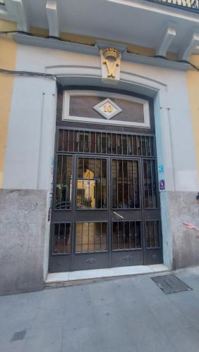 Una puerta a un edificio con un cartel. en HOSTAL ANDREA SOL, en Madrid