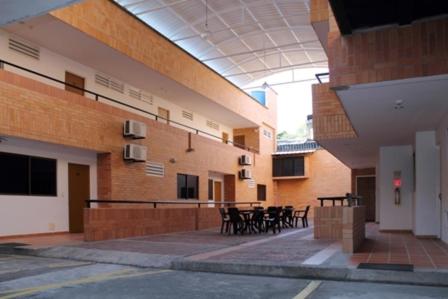 a building with tables and chairs in a courtyard at Apartahotel Los Cerezos in Neiva