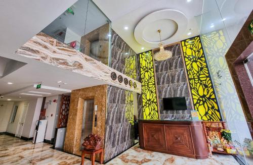 eine Lobby eines Gebäudes mit einer Treppe an der Wand in der Unterkunft Xavia Hotel Quy Nhơn in Quy Nhon