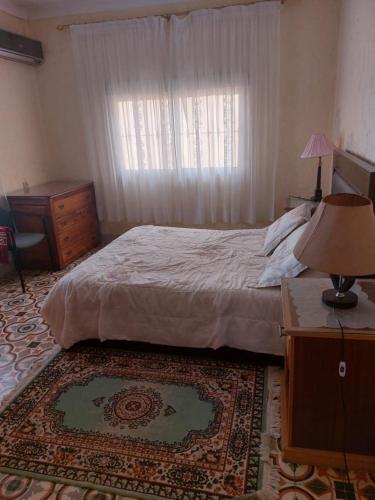 Villa kaoutar في مرتيل: غرفة نوم بسرير وخزانة ونافذة