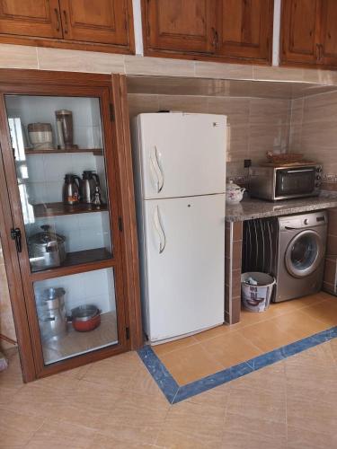 Villa kaoutar في مرتيل: مطبخ مع ثلاجة بيضاء وميكرويف