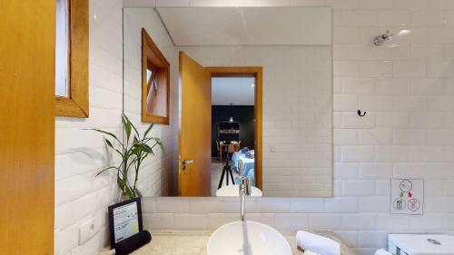 een badkamer met een wastafel en een spiegel bij Studio 4 Pinheiros by Oba in Sao Paulo