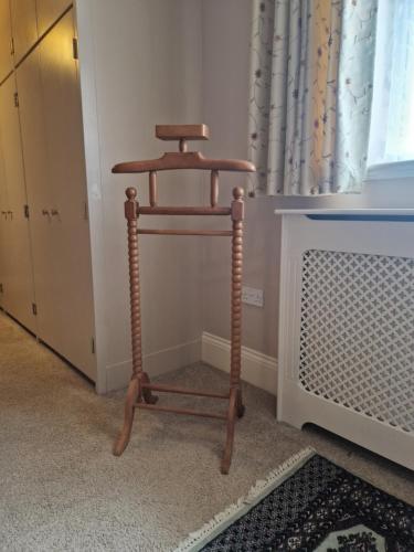 a wooden stool in a room with a radiator at Primroses, Wood Farm in Shipdham