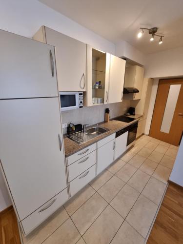 a kitchen with white cabinets and a white refrigerator at City Appartements Villach in Villach
