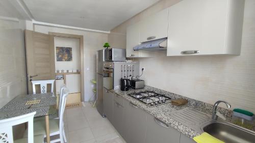 een keuken met een wastafel en een aanrecht bij DLX01 - Appartement Deluxe bien équipé- Centre Ville Oujda in Oujda