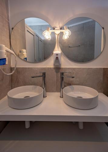 a bathroom with two sinks and a mirror at Sun Lovers Hostel in Albufeira